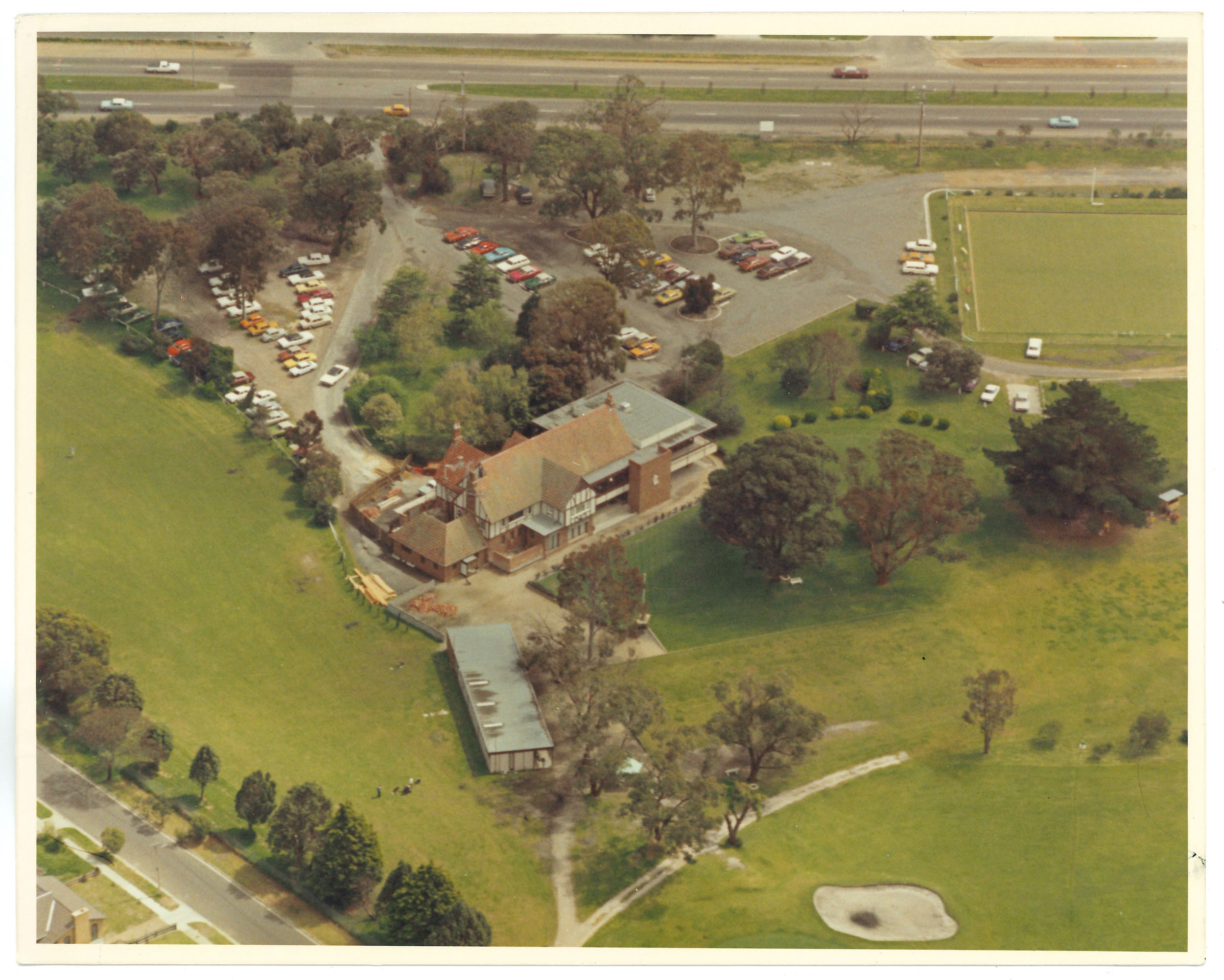An aerial photograph of the clubhouse showing the bowling green to the upper right